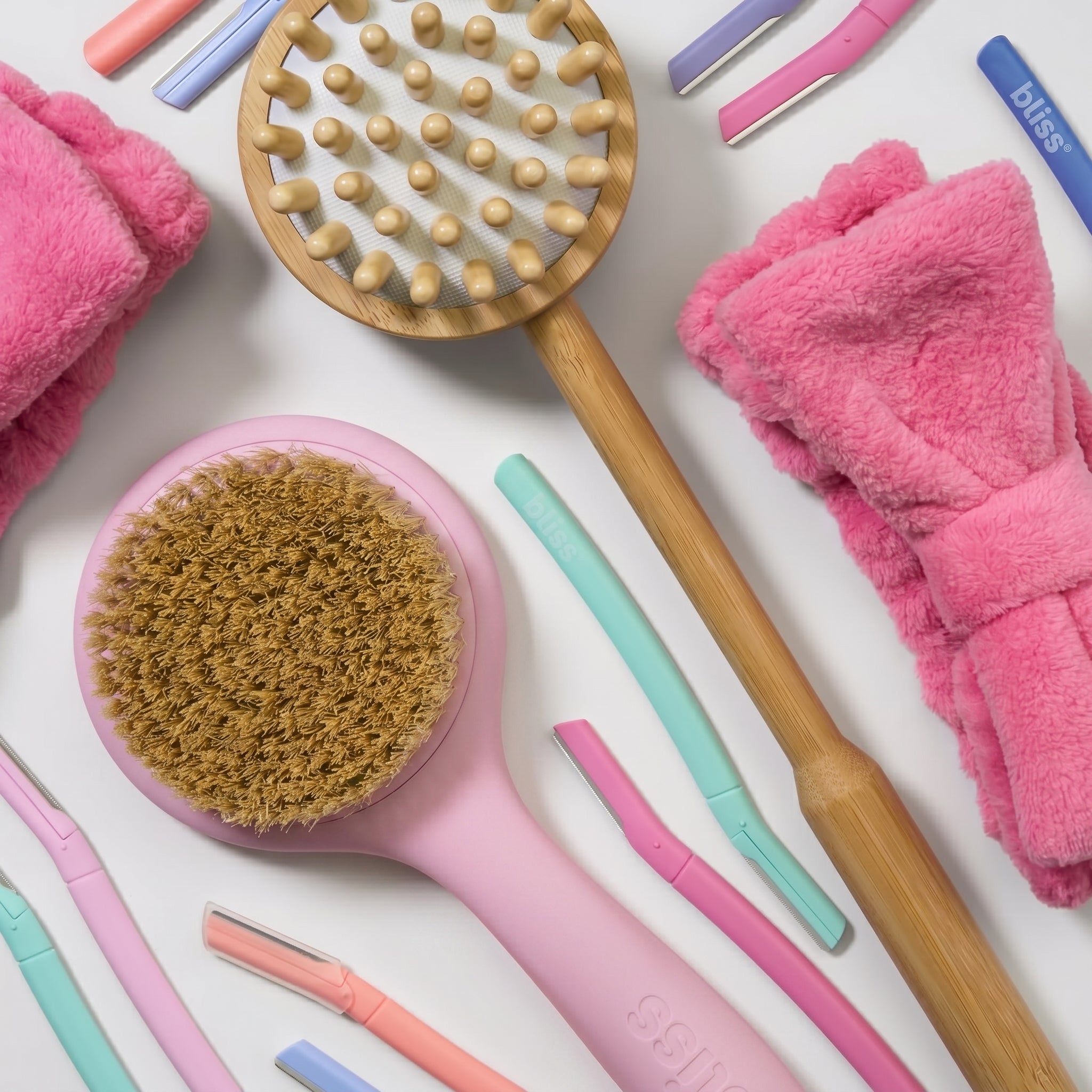 Collection of beauty tools including brushes and towels on a white background
